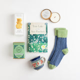 A favorite aunt used to say her idea of perfect peace was a good book and a cup of tea. In her honor, we've put together our version of this simple pleasure with a lovely stoneware mug, "Tom Lake" by Ann Patchett, cozy cashmere mix socks, Meyer lemon shortbread, herbal peppermint tea, plus a vanilla lavender candle for ambiance.
