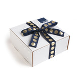 All of our gifts come in our trademark white carton and are tied up with a festive navy and metallic gold dotted ribbon