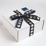 ll of our gifts come in our trademark white carton and are tied up with a festive navy and metallic gold dotted ribbon.
