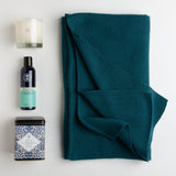 A lovely teal-hued ruana is the star of this carton. It is soft, warm, and stays comfortably in place on the wearer's shoulders. An artfully-designed tin of pomegranate tea, English lavender bath gel, and a calming candle in vanilla lavender round out a gift that would make anyone's day a little dreamier.