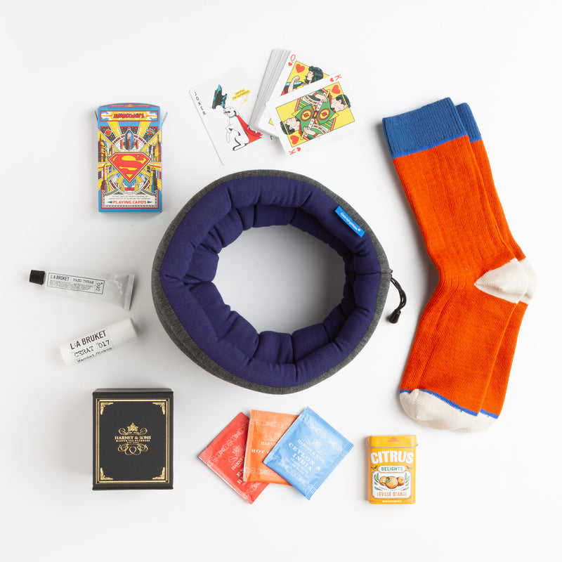 This zesty carton is chock full of items that even a superhero would love. The "versatile" pillow from Ostrich Pillow doubles as an eye mask/pillow and makes any sleeping or sitting position more comfortable. Striking color block socks, a colorful tea assortment, nourishing lip balm, and hand cream by LA Bruket, as well as a vibrant deck of Superman playing cards round out this multifaceted gift.