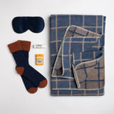 Elevate your comfort game with this handsome reversible blanket from David Fussenegger. Combined with a navy silk eye mask, cashmere mix slouch socks, soothing lip balm, and some zesty citrus mints, this wellness gift is sure to make anyone sleep more soundly.