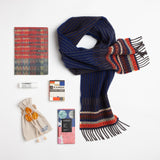 A natty lambswool scarf, combined with a kicky plaid notebook, extra-large lip balm, and a coffee-infused dark chocolate bar make for a stylish way to embrace the winter, even if it's only from the comfort of your couch.