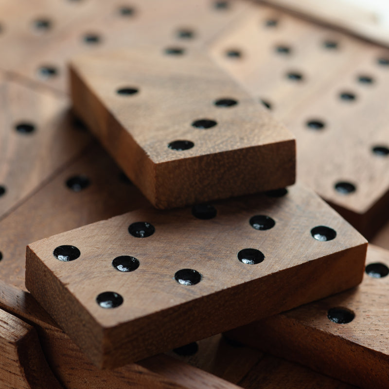 Wooden dominoes with black dots on a wooden surface