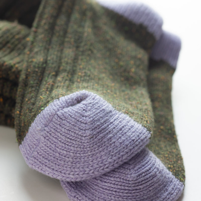 Dark Green Silk Blend Socks by Catherine Tough: These cozy socks have a satisfyingly chunky rib design, but are soft enough to be worn as bed socks. The dark green silk yarn has tweed-like flecks of color throughout, and is accented by lilac heels. Made from virgin silk, lambswool, viscose, and nylon, the socks are a recycled blend of high-quality, Italian spun yarn. Size: 8.5-11.5 US.