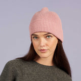 Woman wearing ribbed dusky pink lambswool beanie by Catherine Tough.