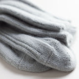 Close-up of silver angora bed socks by Falke. They are produced by a family-owned business that has been making premium socks since 1865 and are known for their "perfect FALKE fit" and soft, non-constricting cuff. Made in Germany.