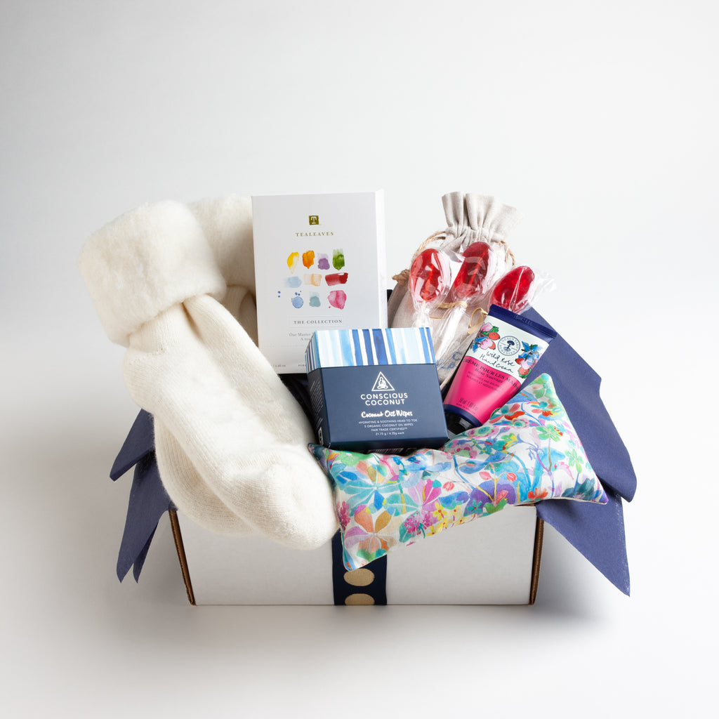 This nurturing gift includes a gorgeous floral eye pillow from Liberty of London, wild rose hand cream, coconut oil wipes, a selection of ten different teas and wool blend socks that define "walking on a cloud." .