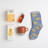 Cozy blue lambswool socks, Meyer lemon shortbread, a dark orange earthenware mug, clover honey, and soothing turmeric tea comprise the perfect prelude to a nap.