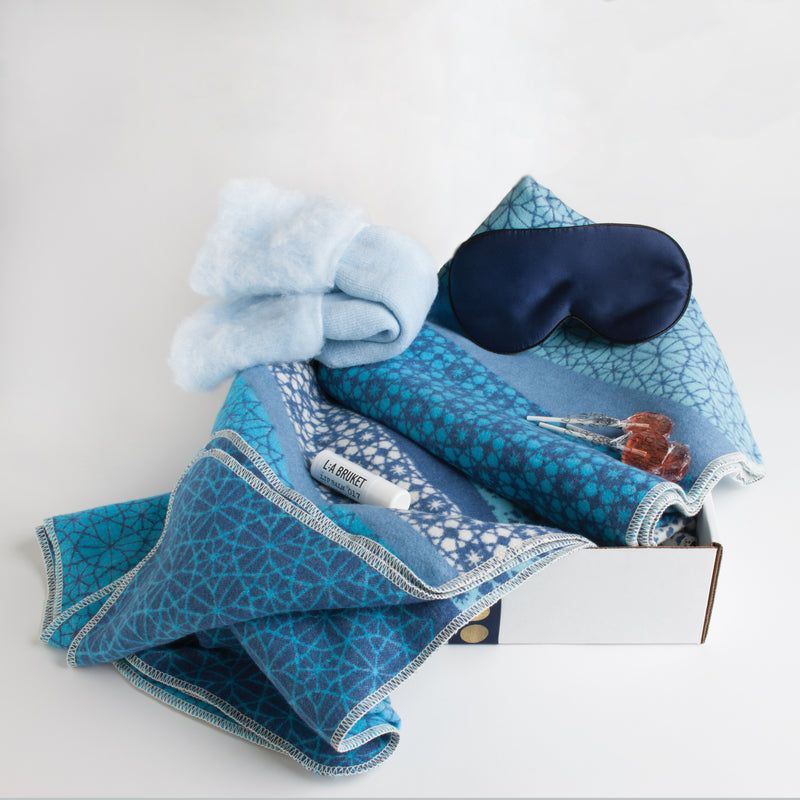 A plush cotton flannel blanket by David Fussenegger, coziest wool socks, a silk eye mask, soothing lip balm and all-natural lollipops ensure the patient's comfort while cat-napping or binge-watching her favorite TV show.