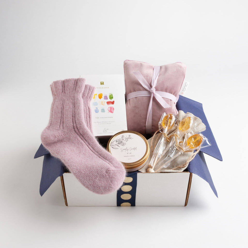 A luxe velvet heat pillow, soft angora bed socks, a botanical travel candle and a colorful tea sampler from TeaLeaves work together to create a sense of peacefulness and calm.